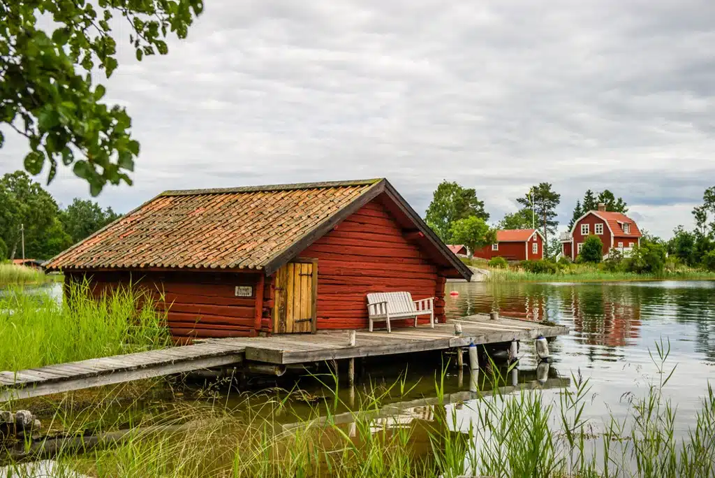 Skärgårdsställe med brygga Rött timmerhus med tegeltak och brygga.
Den Vita träsoffan på bryggan ser inbjudande ut